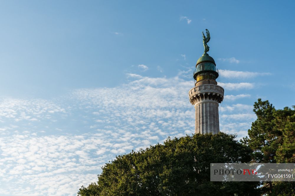 Vision among the trees, lighthouse of Victory, or Faro della Vittoria, National Monument in  Trieste, Friuli Venezia Giulia, Italy, Europe