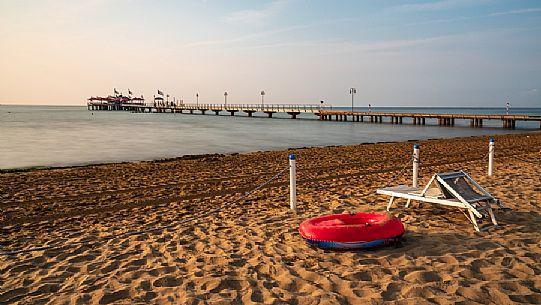 Lone chaise longue in the beach of Lignano Pineta at early morning, Lignano Sabbiadoro, Friuli Venezia Giulia, Italy, Europe