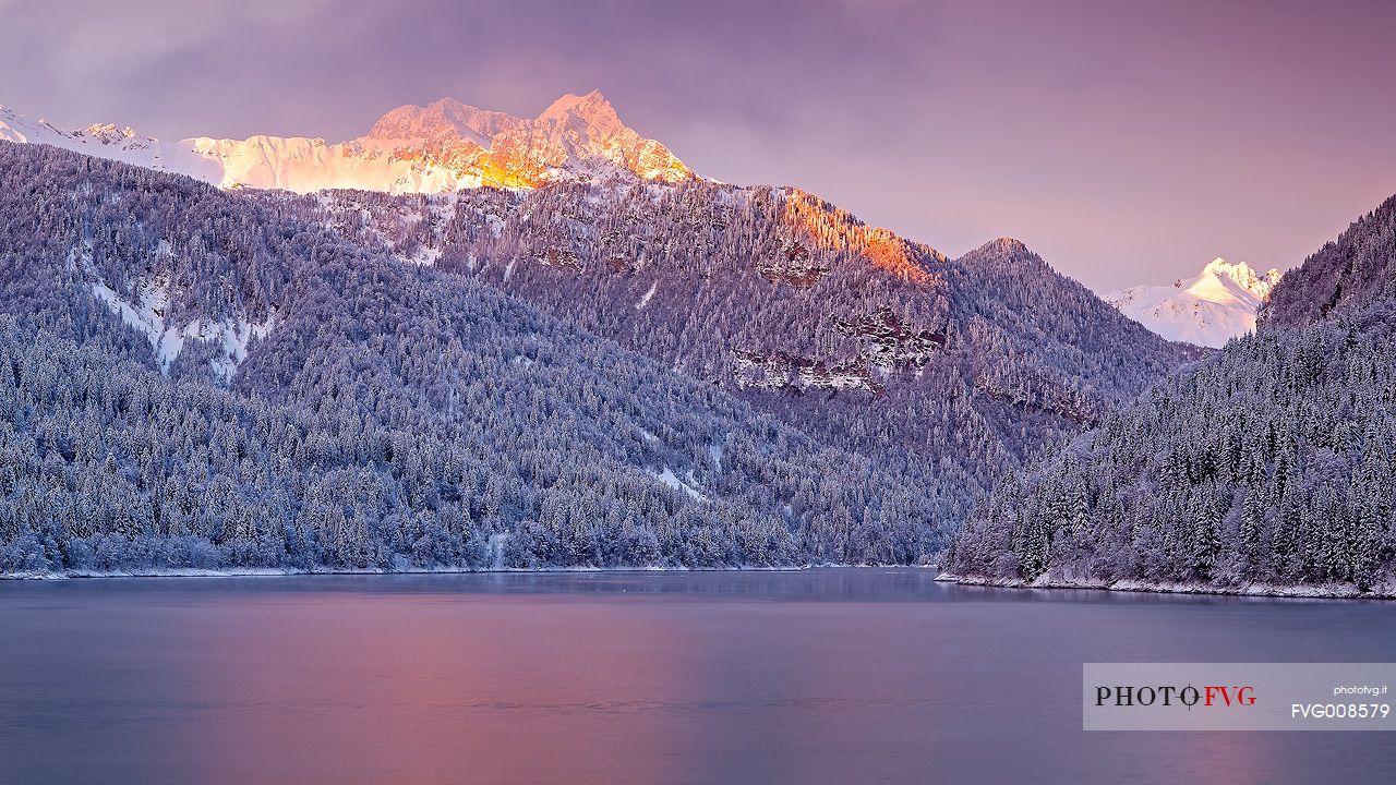 Sauris Lake at dawn after an heavy snowfall