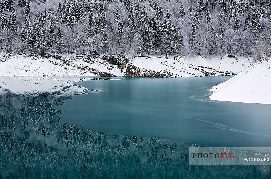 Sauris Lake at dawn after an heavy snowfall