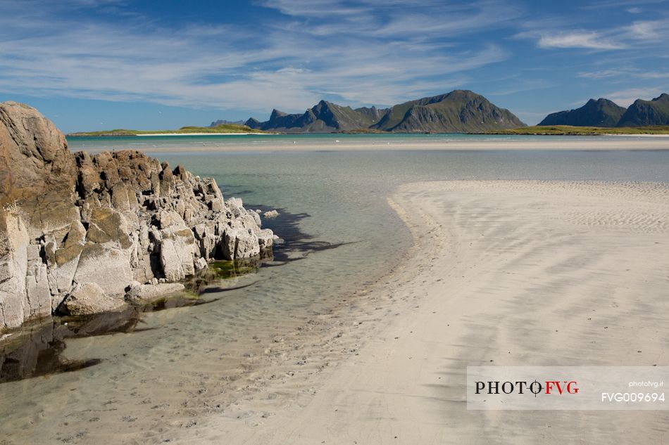 The mountains surrounding the white sand and crystal clear waters of the north coast of Gimsoya