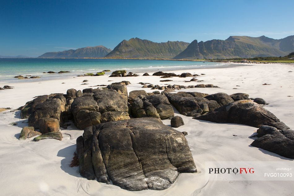 The mountains surrounding the white sand and crystal clear waters of the north coast of Gimsoya