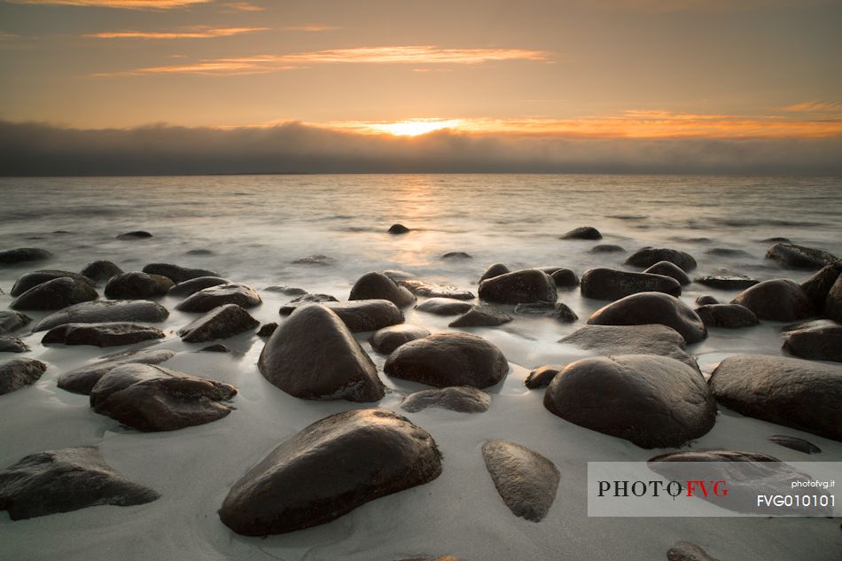 The Sunset on the beach of rounded rocks Utaklein