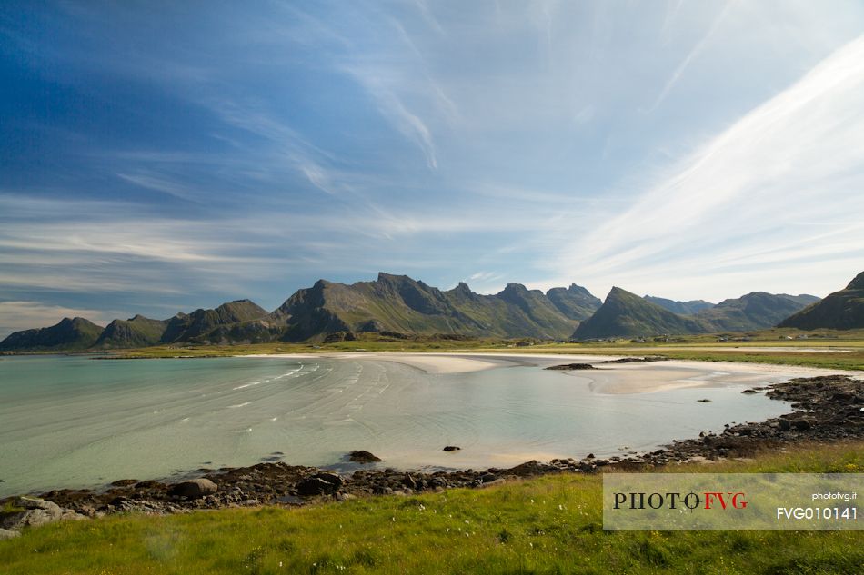 The mountains surrounding the white sand and crystal clear waters of the north coast of Gimsoya