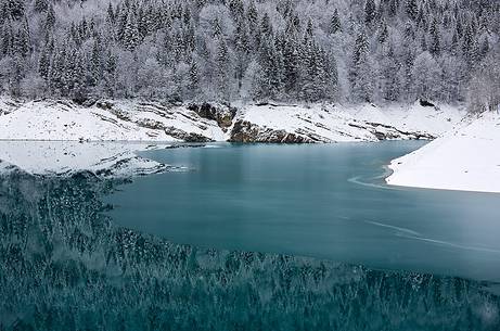 Sauris Lake at dawn after an heavy snowfall