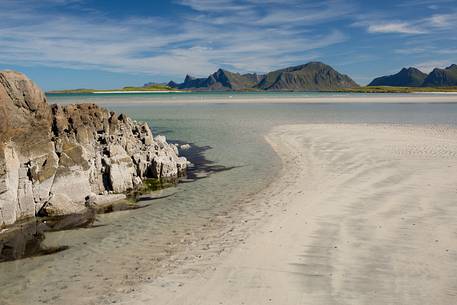 The mountains surrounding the white sand and crystal clear waters of the north coast of Gimsoya