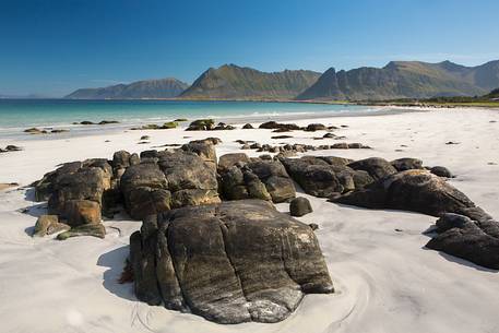 The mountains surrounding the white sand and crystal clear waters of the north coast of Gimsoya