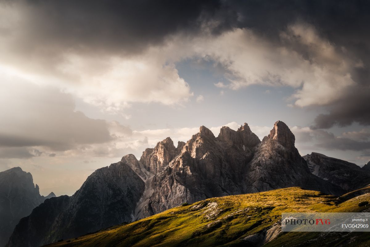 Mount Rudo in the Sesto Dolomites, framed by storm clouds and alpine meadows, South Tyrol, Italy, Europe