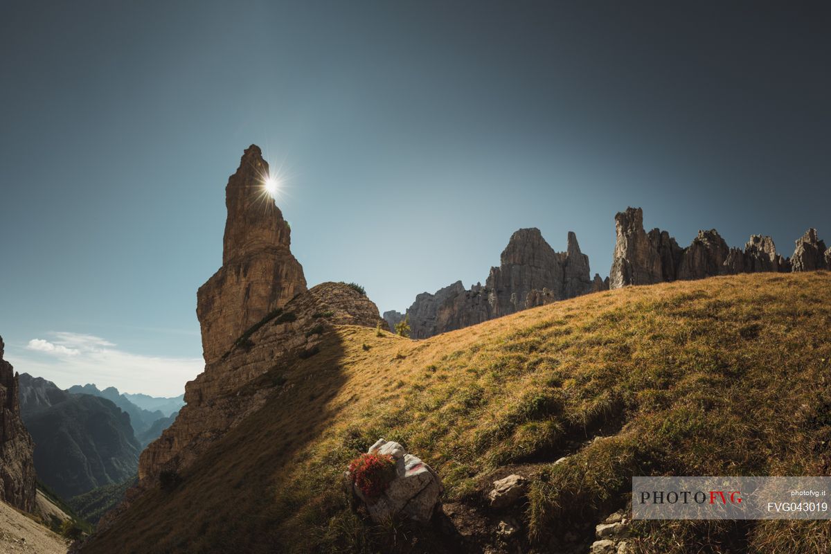 The sun peeks out behind the Campanile di Val Montanaia bell tower, Dolomiti Friulane natural park, dolomites, Friuli Venezia Giulia, Italy, Europe