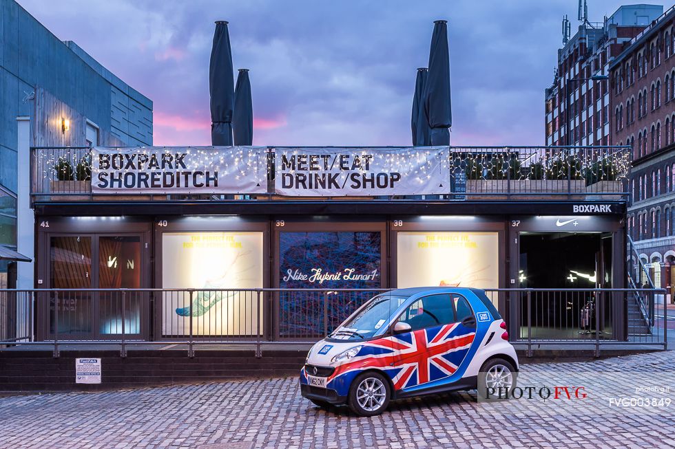 A Smart automobile with english flag in front of one Nike shop in borough of Shoreditch A Smart automobile with english flag in front of one Nike shop in borough of Shoreditch