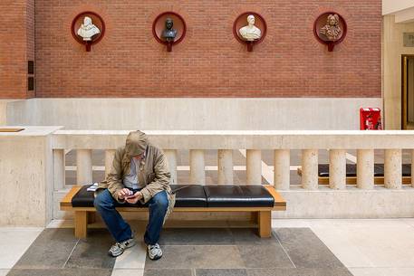 A view inside the British Library. One man look your smartphone.