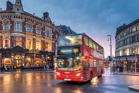 One of famouse red double-dekers buses in a borough of Clapam at the dusk