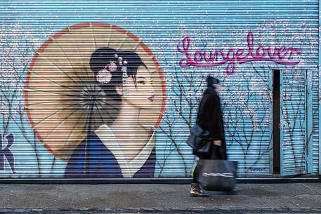 Young girl in front of one murales in borough of Shoreditch Young girl in front of one murales in borough of Shoreditch