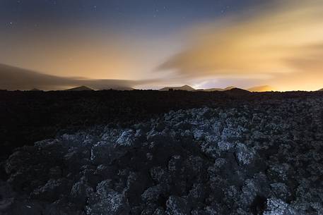 A night view of volcanos skyline over lava field