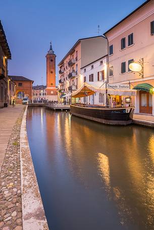 Evening view of Torre dell'Orologio with a ship and a tipical restaurant near the Loggia del Grano palace