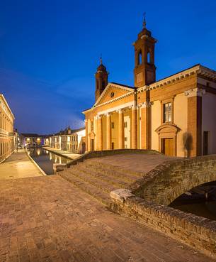 Evening view of a small centre's river in front of Ex Ospedale San Camillo in the moonlight, Comacchio
