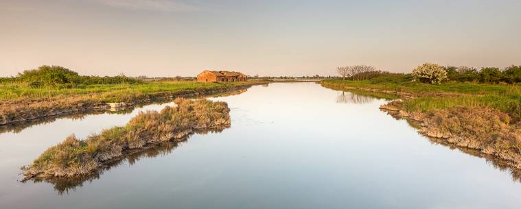 An old house for fishing anguilla on the Comacchio's lagoon at the dusk An old house for fishing anguilla on the Comacchio's lagoon at the dusk