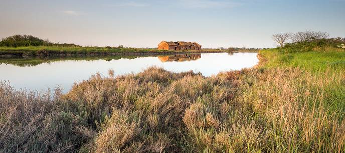 An old house for fishing anguilla on the Comacchio's lagoon at the dusk An old house for fishing anguilla on the Comacchio's lagoon at the dusk