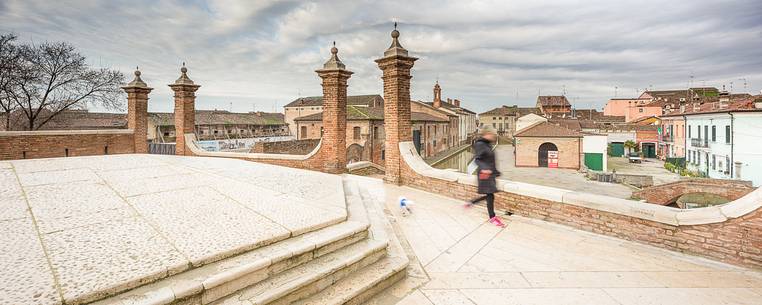 Morning view from Tre Ponti bridge with a woman and a dog