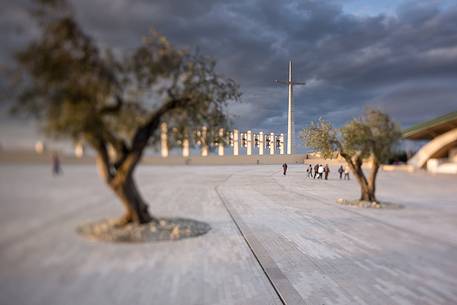 Some pilgrims walk on the square in front of Padre Pio's church at the sunrise