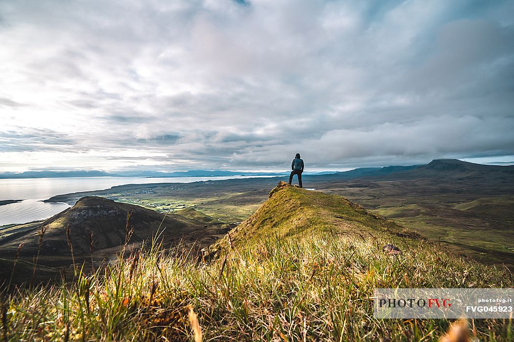 A hiker enjoying the view at lunar landscape of Quiraing on the Trotternish peninsula, Isle of Skye, Scotland, United Kingdom, Europe