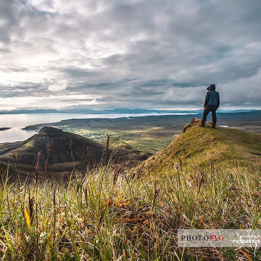 A hiker enjoying the view at lunar landscape of Quiraing on the Trotternish peninsula, Isle of Skye, Scotland, United Kingdom, Europe