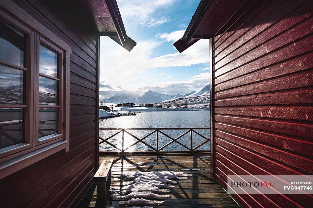 View of the Lyngen Alps in winter time from a typical house of fishermen called rorbu in the village of Nordlenangen, Troms, Norway, Europe
