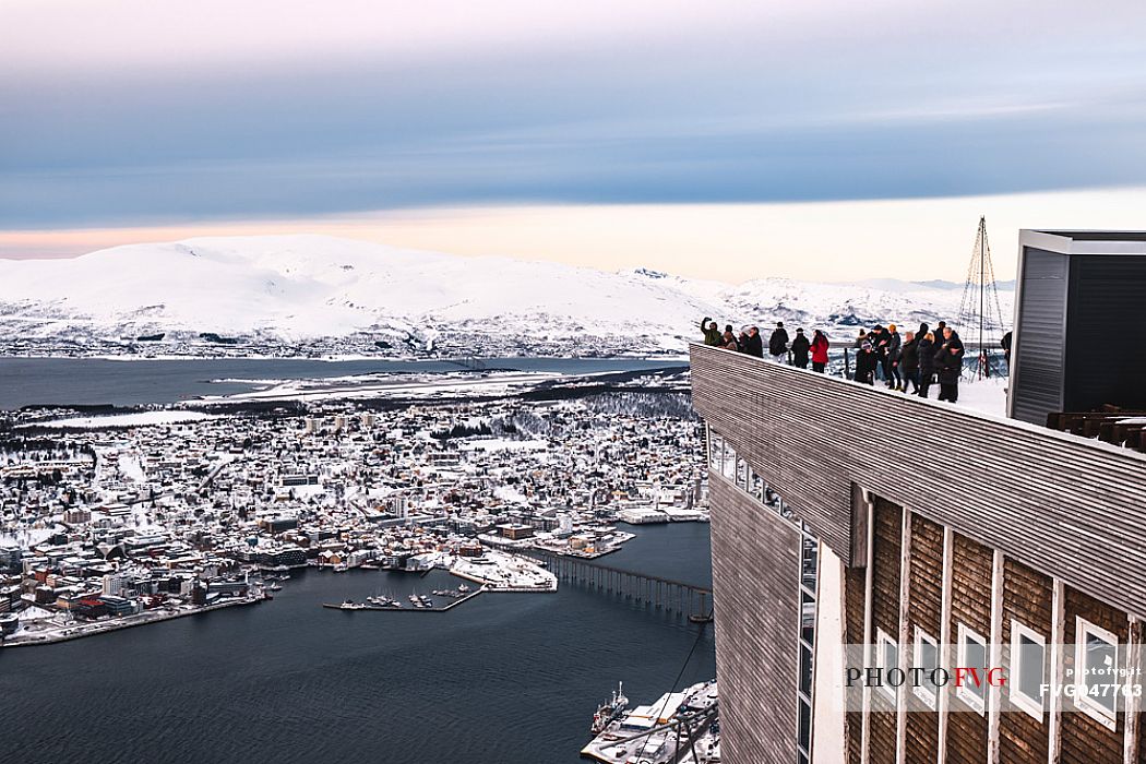 Tourists on the top Station of Fjellheisen Cable Car on Storsteinen Mountain (418m) with view of the city and Tromsoysund, Tromso, Norway, Europe