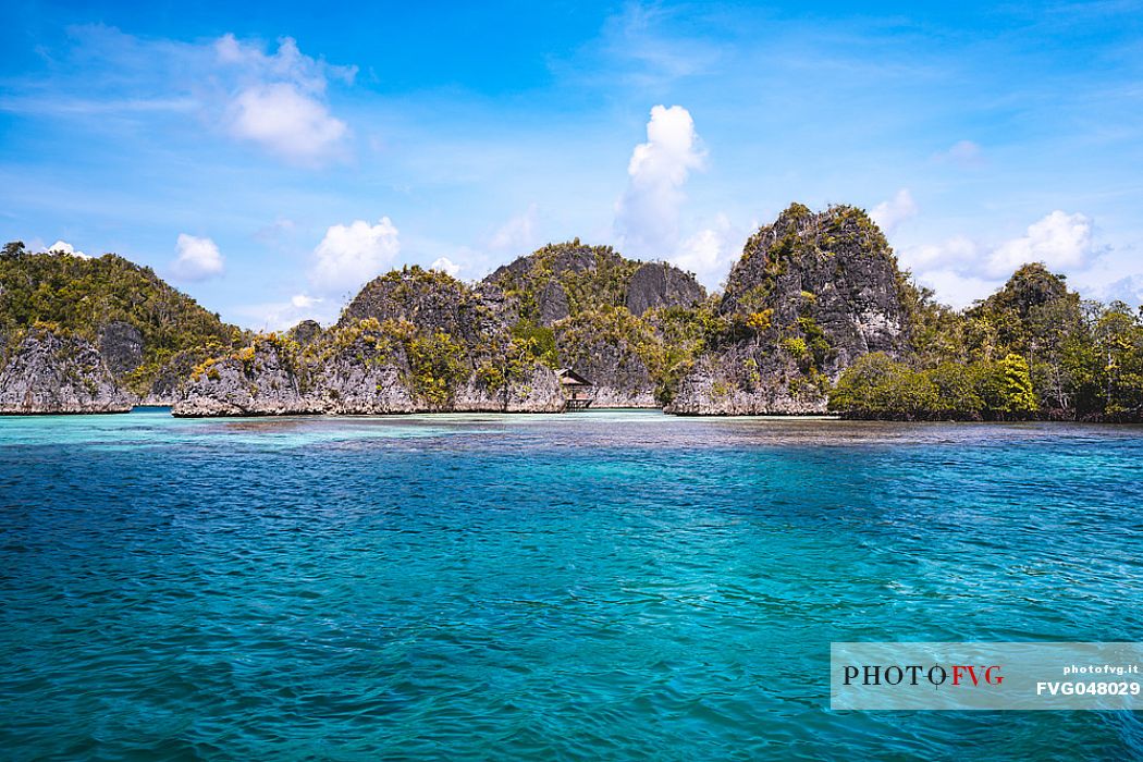 Approaching Piaynemo island, one of the Raja Ampat archipelago most popular tourist spots.
This is one of thousand island located in the northwestern sea of West Papua, one of the most remote province of Indonesia. There are about 1500 thousand island, the largest islands are: Waigeo, Misool, Batanta and Salawati.  The coral reef and the marine biodiversity of Raja Ampat hold the richest variety of species in the world. 
The seascape is enriched by hundreds of small islands with a unique and particular shape. This rock formations despite the arid nature are covered by a rich vegetation. 