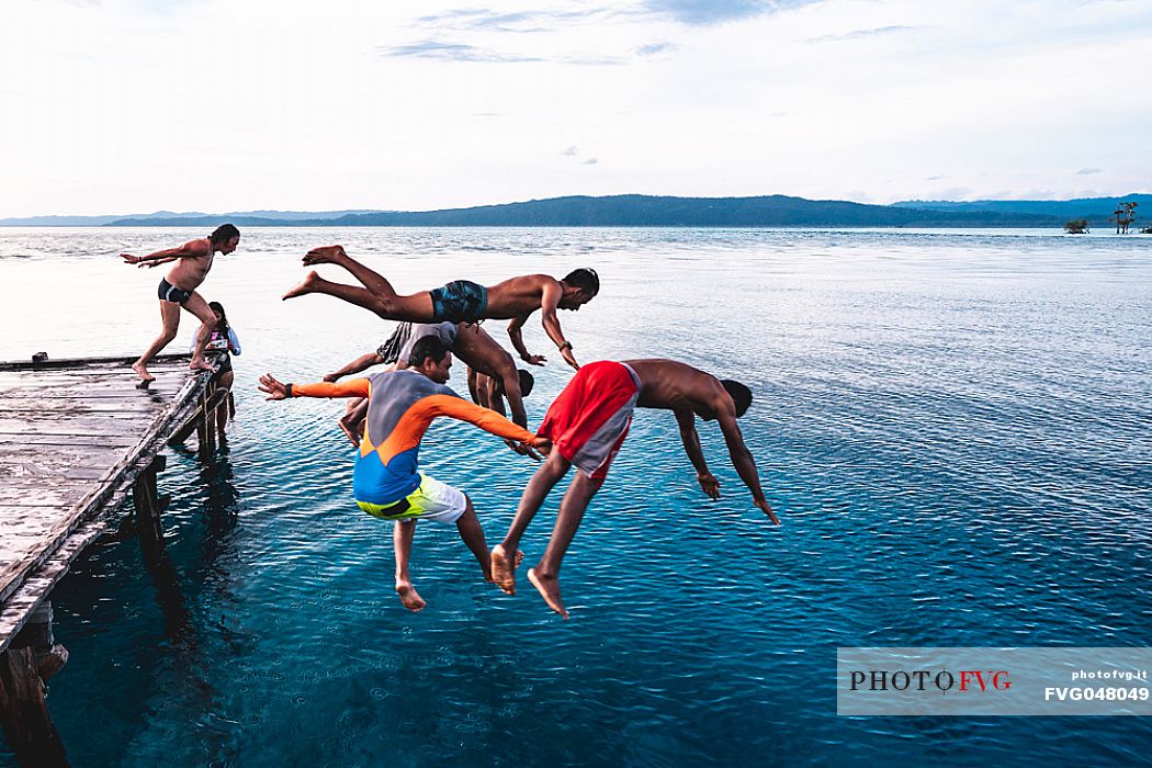 Group of people dives in the wonderful sea of the Kri island, one of the Raja Ampat archipelago most popular tourist spots, West Papua, Indonesia