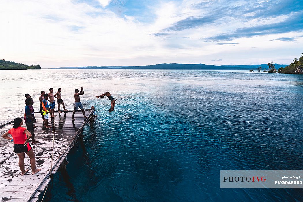 Group of people dives in the wonderful sea of the Kri island, one of the Raja Ampat archipelago most popular tourist spots, West Papua, Indonesia