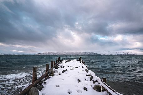 Old pier on the shoreline near Bakkejord, on the road Leirstrandvegen to Tromso, Norway, Europe Old pier on the shoreline near Bakkejord, on the road Leirstrandvegen to Tromso, Norway, Europe