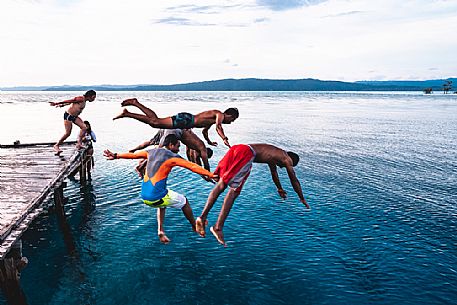 Group of people dives in the wonderful sea of the Kri island, one of the Raja Ampat archipelago most popular tourist spots, West Papua, Indonesia