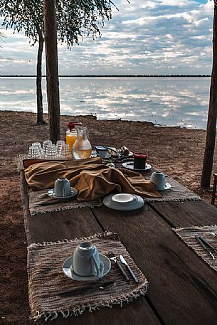 Breakfast mugs on the wooden table in front of Flamenco lagoon in the Paraguayan Chaco near the Reserva Natural - Campo Mara, Paraguay, America