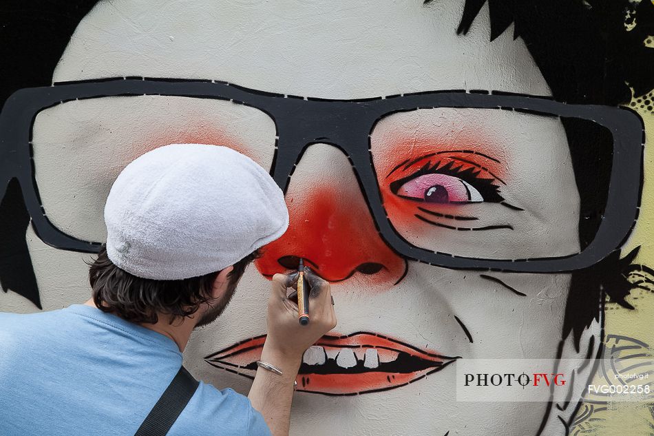 Id-iom street art artists painting a graffiti.