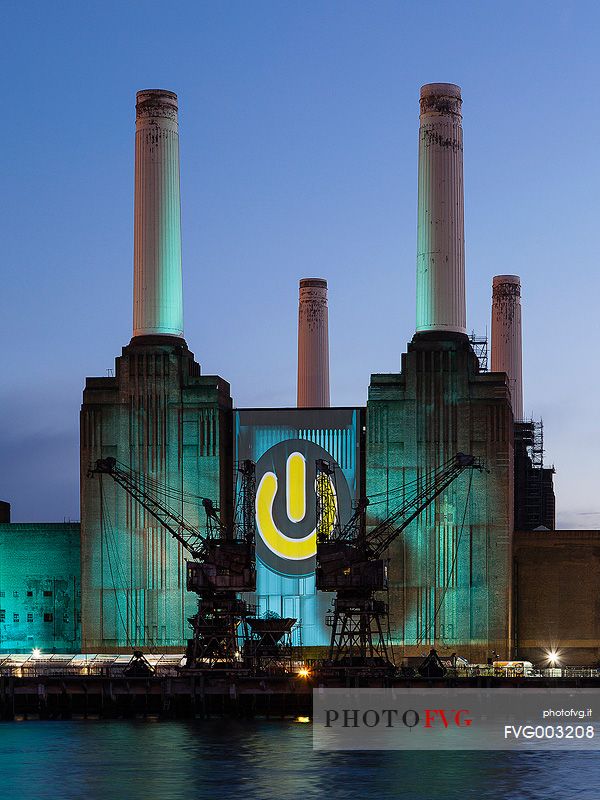 Battersea power station illuminated by colored light of 4G advertising at dusk