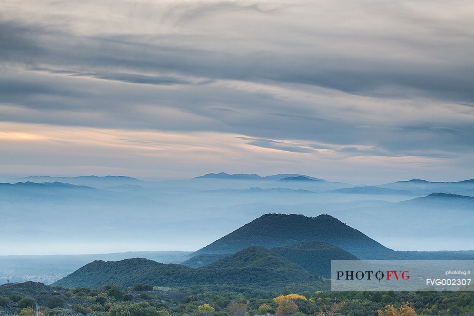 Autumn fogs descend into the valley on the western slope of the volcano. Among the craters of Piano dei Grilli stands overgrown the crater of Mount Minardo.