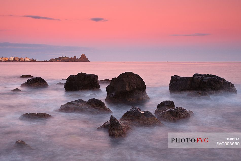 Last light at dusk, in the background the Cyclopes stacks of Acitrezza