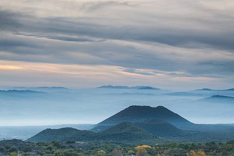 Autumn fogs descend into the valley on the western slope of the volcano. Among the craters of Piano dei Grilli stands overgrown the crater of Mount Minardo.