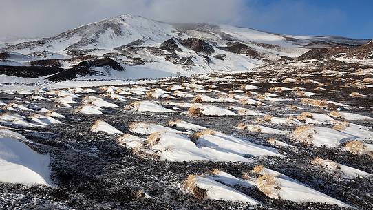 Snow formations molded by the wind. In the background the 2001 eruption craters