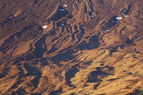 South west face of Mount Etna, the last traces of snow resist in hot summer season