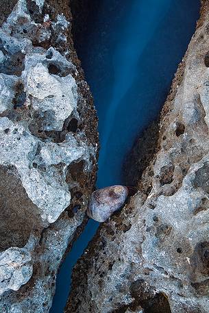 The sea creeps along a small crevice of the Brucoli's cliff.