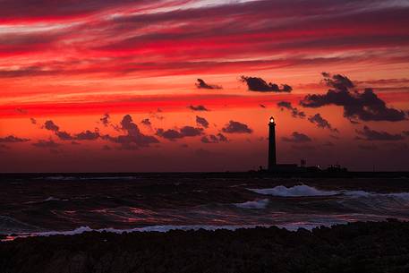 A fiery sunset in Favignana, in the background the lighthouse of Punta Sottile. A fiery sunset in Favignana, in the background the lighthouse of Punta Sottile.