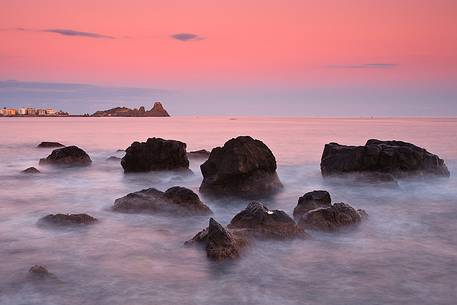 Last light at dusk, in the background the Cyclopes stacks of Acitrezza