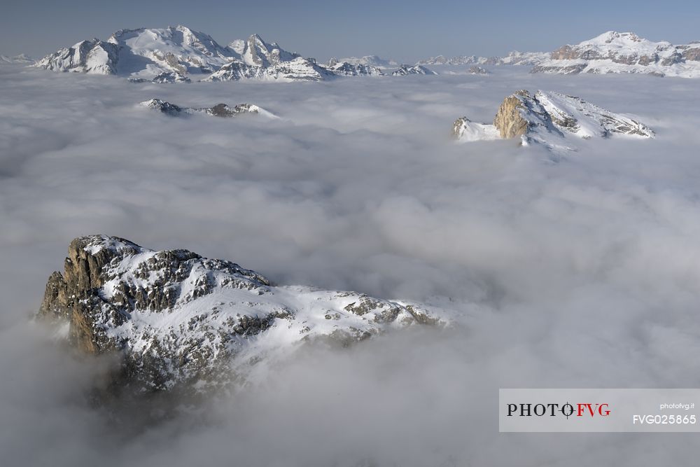 Cold and windy winter morning with the phenomenon of thermal inversion from the top of the mountain Lagazuoi towards the Marmolada glacier and Sella mount, dolomites, Italy
