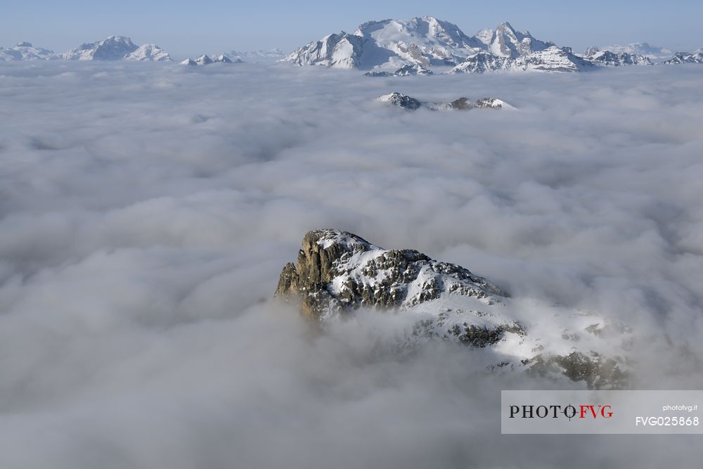 Cold and windy winter morning with the phenomenon of thermal inversion from the top of the mountain Lagazuoi towards the Marmolada glacier and Sella mount, dolomites, Italy
