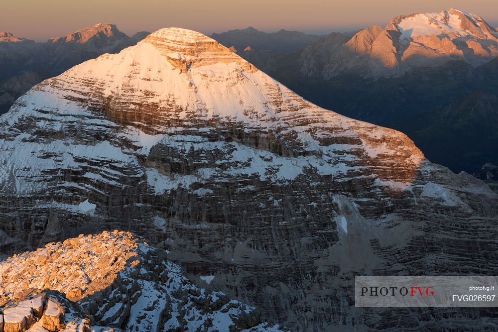 Dawn from the top of Tofana di Mezzo (3244 m) towards Tofana di Rozes after a slight summer snowfall, in the background the Marmolada glacier, Cortina d'Ampezzo, dolomites, Italy