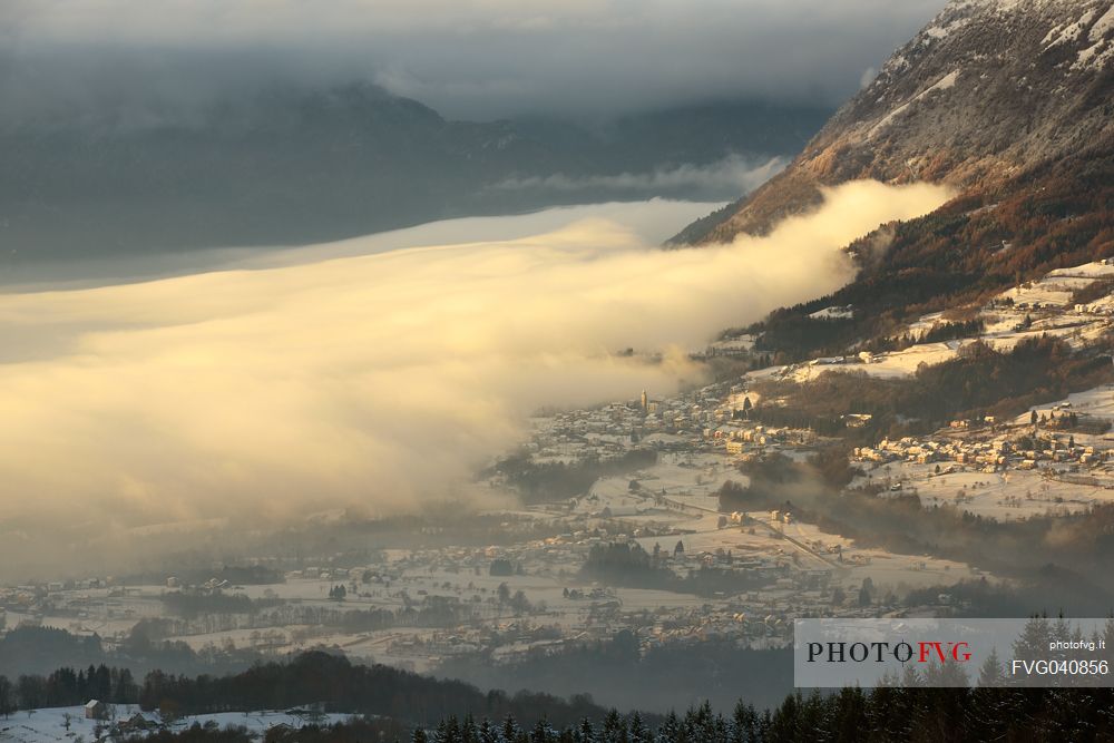The fog descends on the villages of the Alpgao, Pieve d'Alpago village from above, Cansiglio forest, Veneto, Italy, Europe