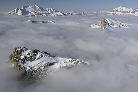 Cold and windy winter morning with the phenomenon of thermal inversion from the top of the mountain Lagazuoi towards the Marmolada glacier and Sella mount, dolomites, Italy
