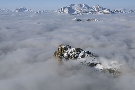 Cold and windy winter morning with the phenomenon of thermal inversion from the top of the mountain Lagazuoi towards the Marmolada glacier and Sella mount, dolomites, Italy
